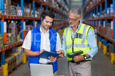 Workers colleague looking at digital tablet in warehouse