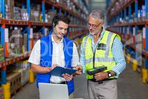 Workers colleague looking at digital tablet in warehouse