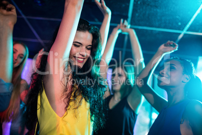 Group of smiling friends dancing on dance floor