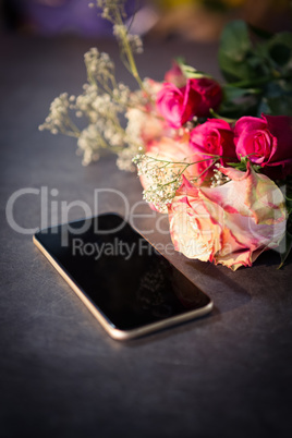 Pink roses and smartphone on the table