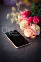 Pink roses and smartphone on the table