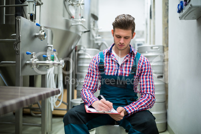 Maintenance worker writing on clipboard