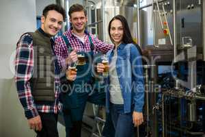 Brewers holding beer glasses at brewery factory
