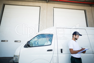 Low angle view of delivery man is writing on a clipboard