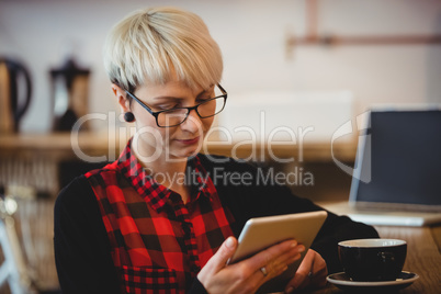 Woman using digital tablet at office cafeteria