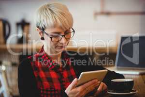 Woman using digital tablet at office cafeteria