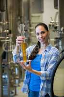 Female brewer holding hydrometer cylinder