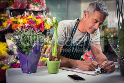 Male florist writing on clipboard