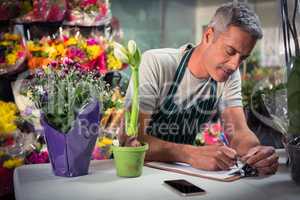 Male florist writing on clipboard