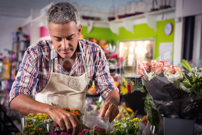 Male florist arranging bouquet of flower