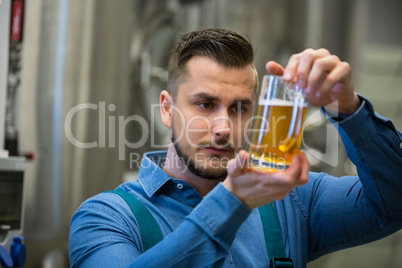 Close-up of brewer testing beer