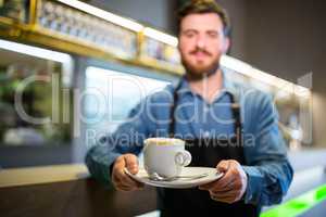 Waiter holding cup of coffee