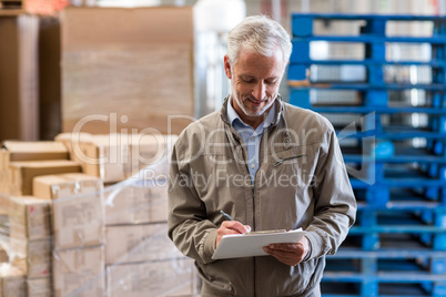 Portrait of manager is looking a clipboard and smiling