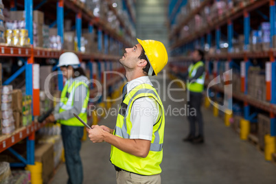 Worker looking up in warehouse