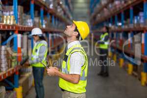 Worker looking up in warehouse