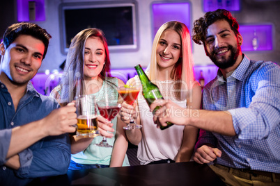 Group of friends toasting cocktail, beer bottle and beer glass a
