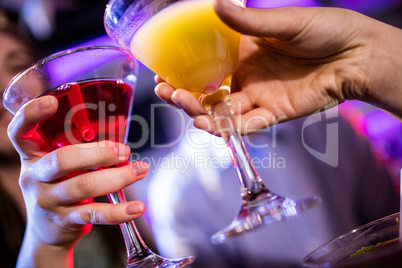 Friends toasting cocktail at bar counter