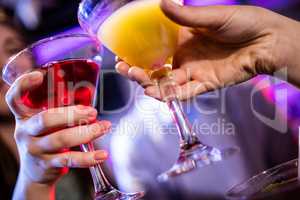 Friends toasting cocktail at bar counter