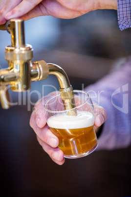 Close-up of waiter pouring beer