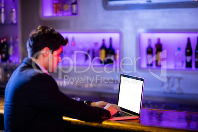 Man using laptop at bar counter