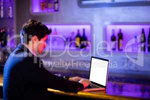 Man using laptop at bar counter