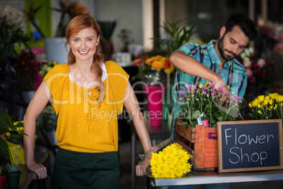 Female florist standing while male florist arranging flower bouq