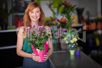 Female florist holding flower bouquet at flower shop