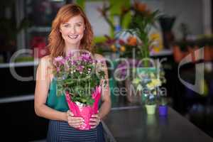 Female florist holding flower bouquet at flower shop