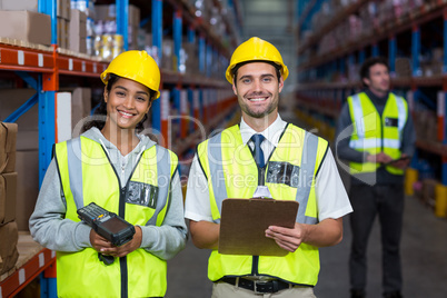 Smiling worker wearing yellow safety vest looking at camera