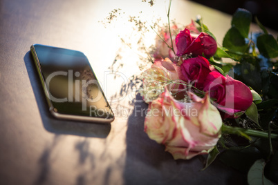Roses and smartphone on the table