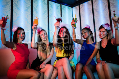 Group of happy friends sitting together and showing mocktails