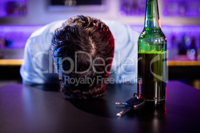 Depressed drunk man sleeping with his head on the table