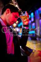 Depressed man having whisky at bar counter