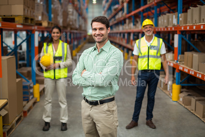 Focus on manager is posing with crossed arms in front of his wor