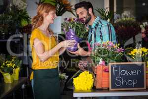 Female florist giving flower bouquet to man