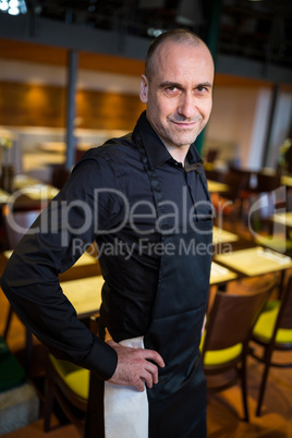 Happy waiter standing in resturant