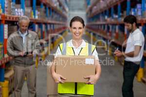 Focus on worker is holding cardboard box and smiling