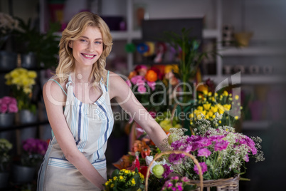 Happy female florist standing in flower shop