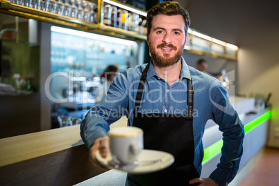 Waiter offering cup of coffee