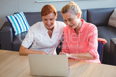 Nurse and senior woman using a laptop