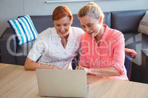 Nurse and senior woman using a laptop