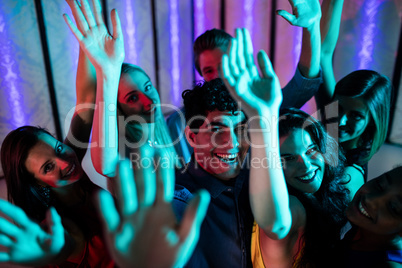 Group of smiling friends dancing on dance floor