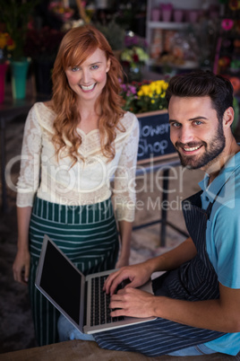 Portrait of happy couple using laptop