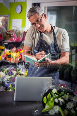 Male florist taking order on mobile phone