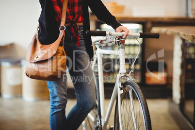 Mid section of woman standing along with bicycle
