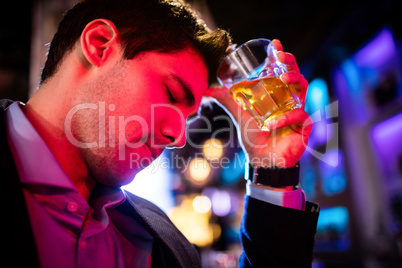 Depressed man having whisky at bar counter