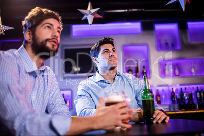 Friends sitting at bar counter and having beer