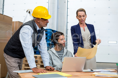 Warehouse worker team looking at document