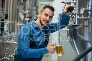 Brewer testing beer from tank