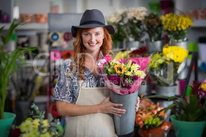 Happy female florist holding flower vase